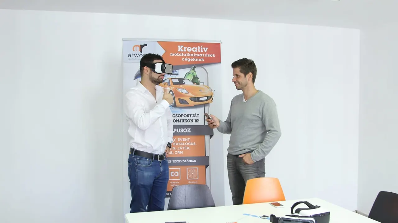 Two professionals: one in a VR headset, the other steering the experience from a phone