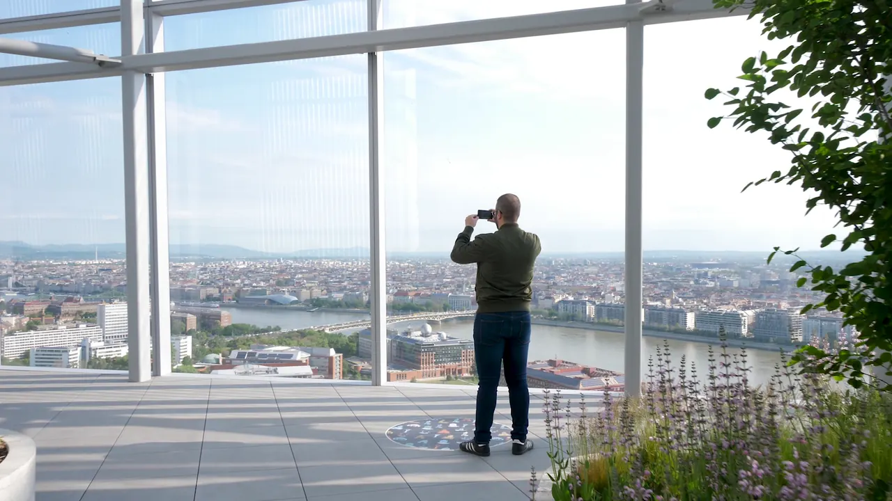 A visitor photographing the Budapest panorama from the MOL Campus rooftop terrace